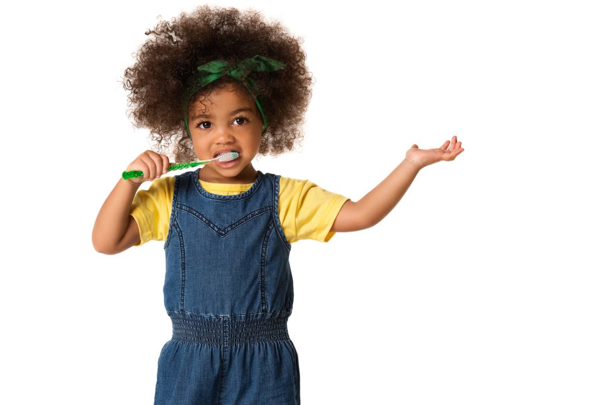 Child brushing teeth asking about common dental care for kids