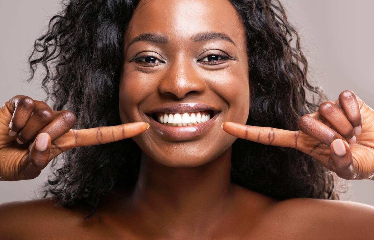 Woman smiling after teeth whitening aftercare